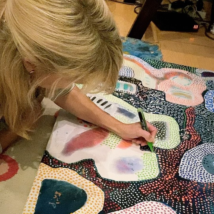 Louise working on a large dotted painting in the atelier