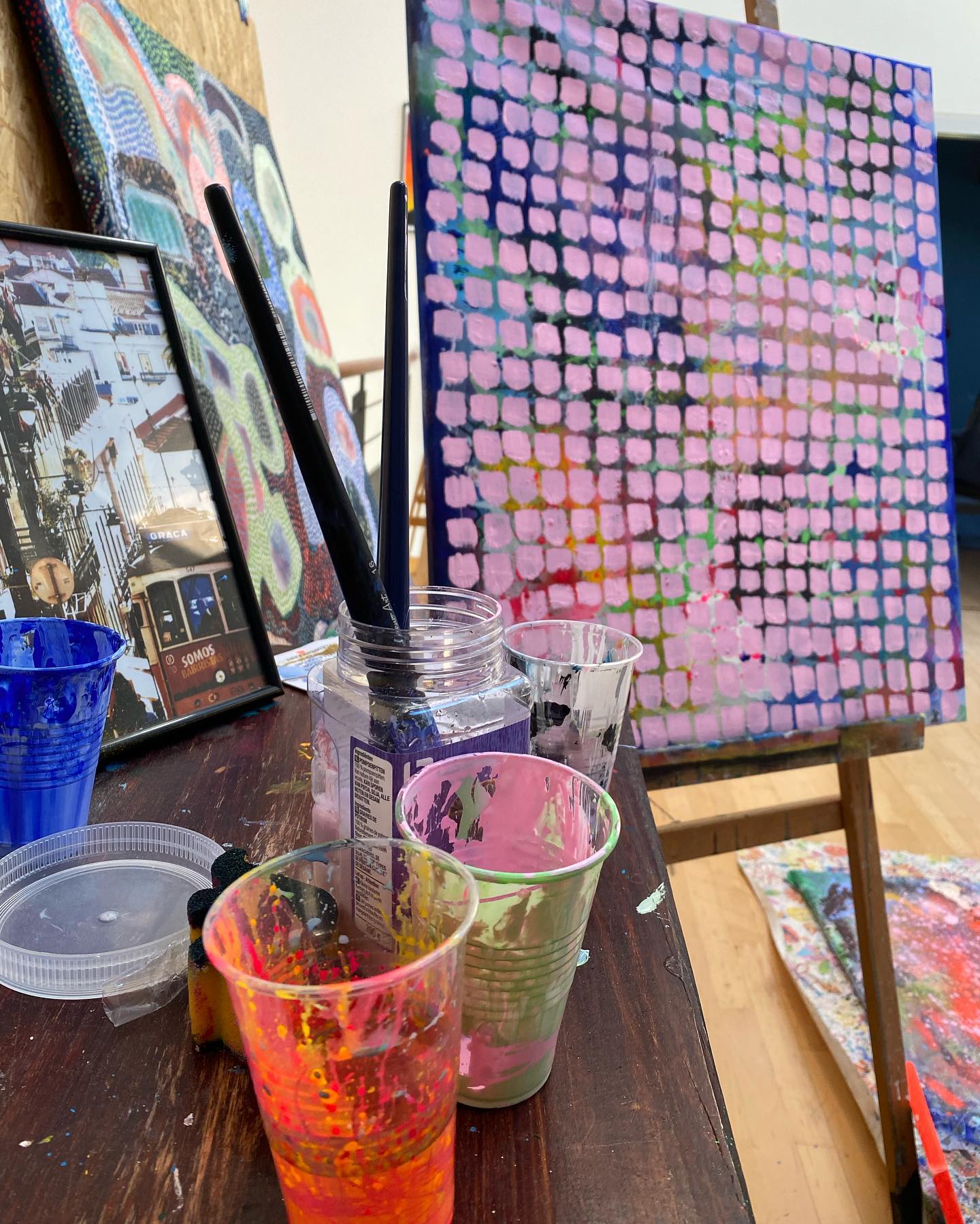 Louise's atelier with a painting on the easel and work supplies on the table