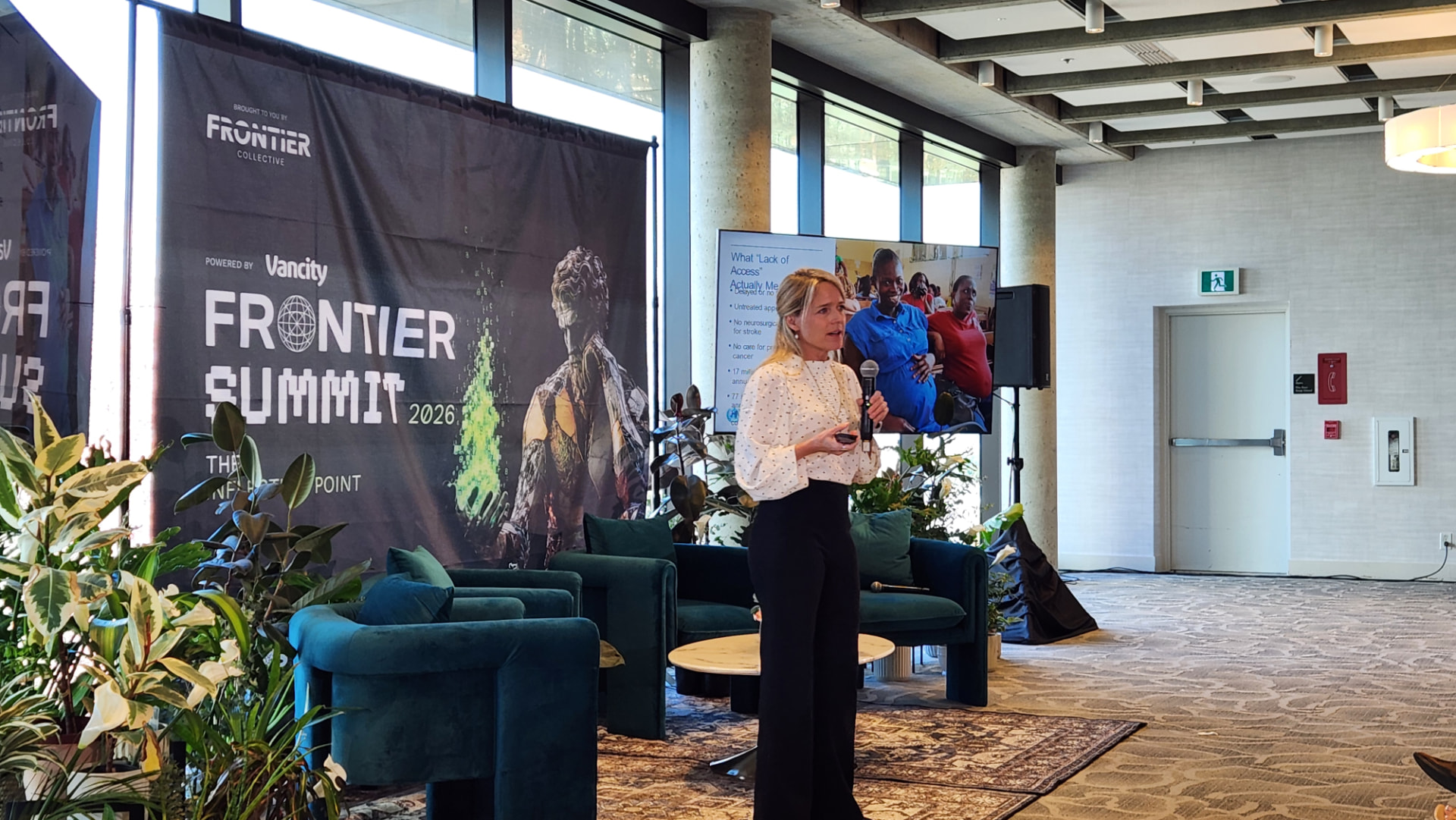 Louise Agersnap presenting on stage at Frontier Summit 2026 in Vancouver, microphone in hand, with the event backdrop and a presentation screen behind her